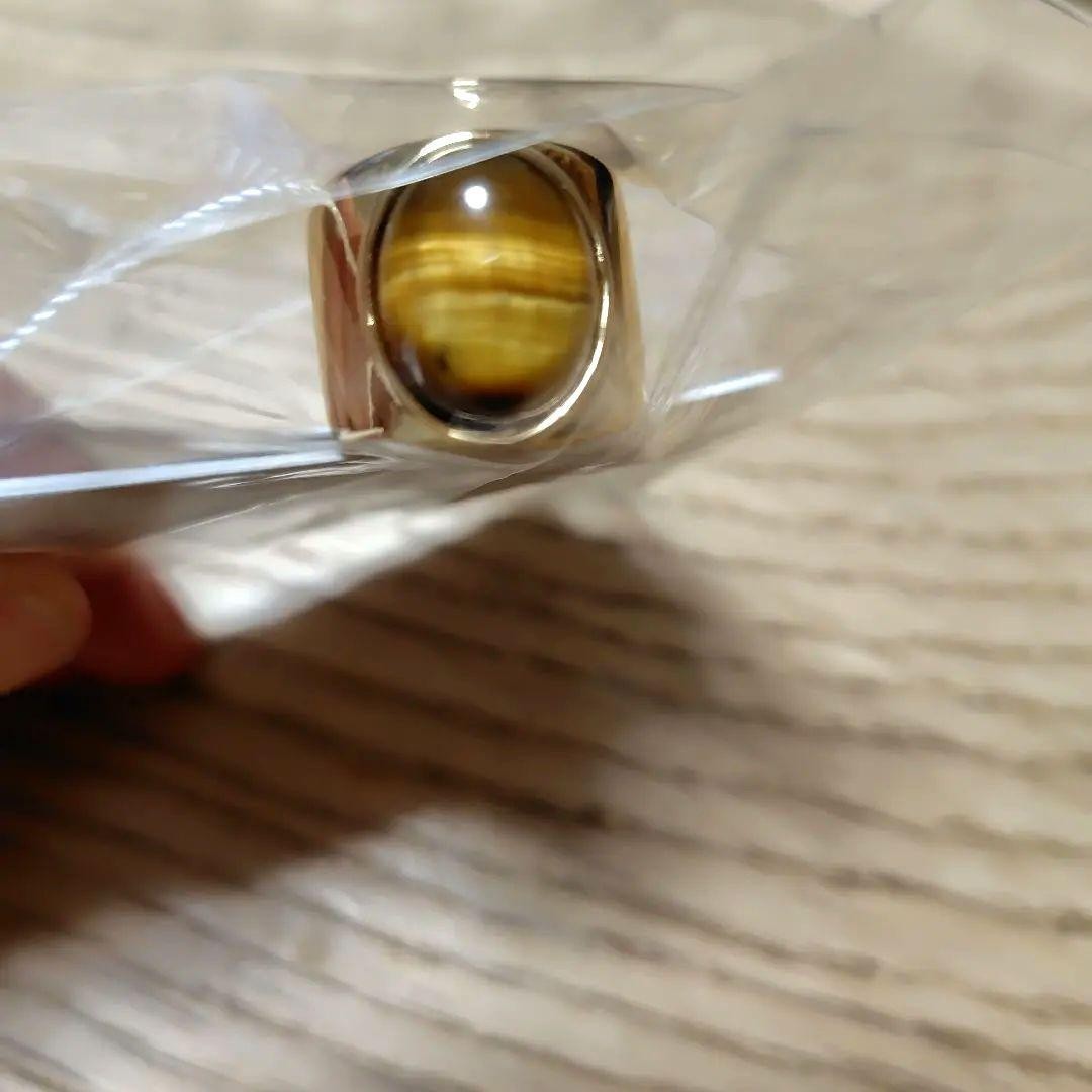 A gold ring with a spherical design featuring onyx and tiger's eye stones.