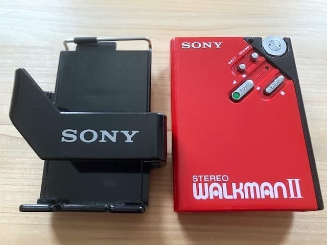 Excellent condition, fully functional Sony WM-2 holder & new headphones.