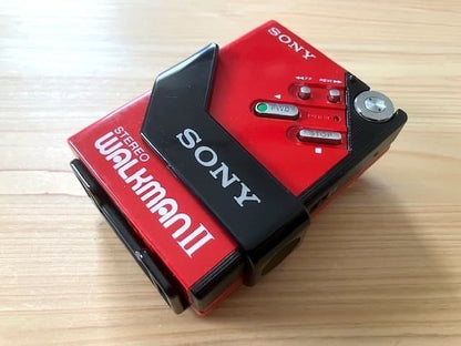 Excellent condition, fully functional Sony WM-2 holder & new headphones.